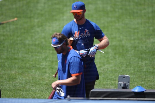 Mets first baseman Pete Alonso and infielder Jeff McNeil enter the dugout after taking batting practice.