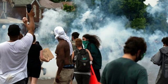 Protesters against police brutality clash with police during a march near where 20-year-old Hakeem Littleton was killed in a shootout with Detroit police earlier in the day, Friday July 10, 2020, in Detroit. (Nicole Hester/Ann Arbor News via AP)