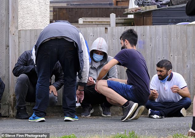 Police and Border Force officers rounded up another group of migrants (pictured) who made the treacherous journey across the Channel in a dinghy before landing on a beach next to the Port of Dover
