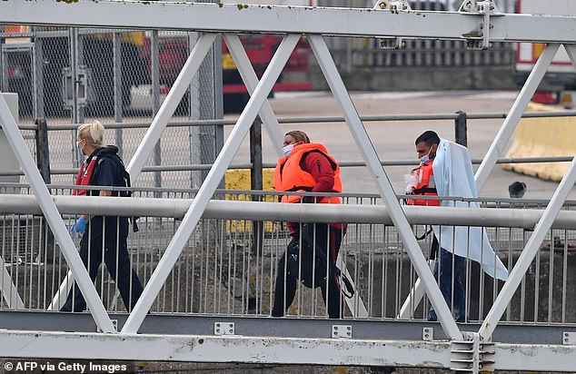 UK Border Force officials escort migrants picked up at sea while attempting to cross the English Channel