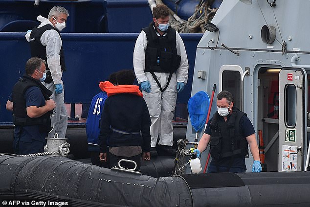 Officials were seen disinfecting patrol vessel HMC Eagle yesterday as migrants were escorted away