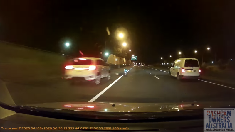 A man is seen rolling onto the motorway as a car with the dashcam approaches a parked vehicle. Source: Dash Cam Owners Australia/Facebook
