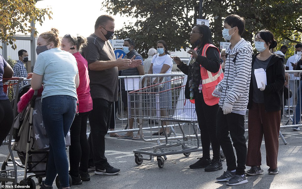 People could be seen wearing masks as they queued behind barriers outside the Chingford Costco in north London